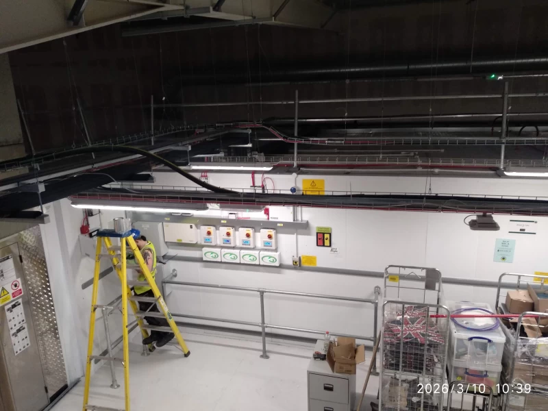Shot taken from ceiling of engineer carrying out electrical works in new store