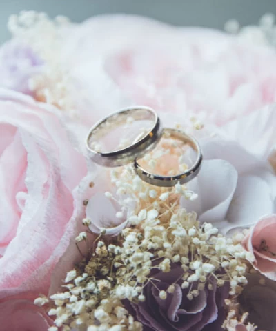 Brown leather key ring with brass metal loops and rivets on wood table.