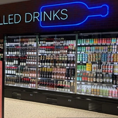 Chilled drinks cabinet containing bottles and cans in M&S Foodhall