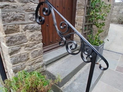 Image Captioned: We were asked to make a handrail to match the scroll pattern in an existing gate, the customer was vey pleased with the result