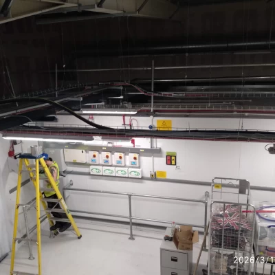 Shot taken from ceiling of engineer carrying out electrical works in new store